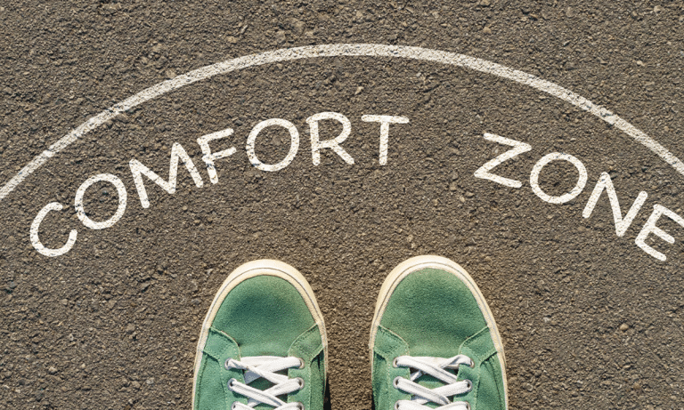 The words Comfort Zone written on a round mat with green running shoes showing